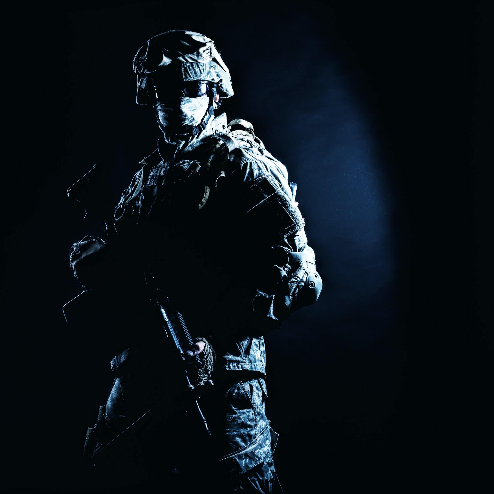 Infantry rifleman standing with weapon in darkness