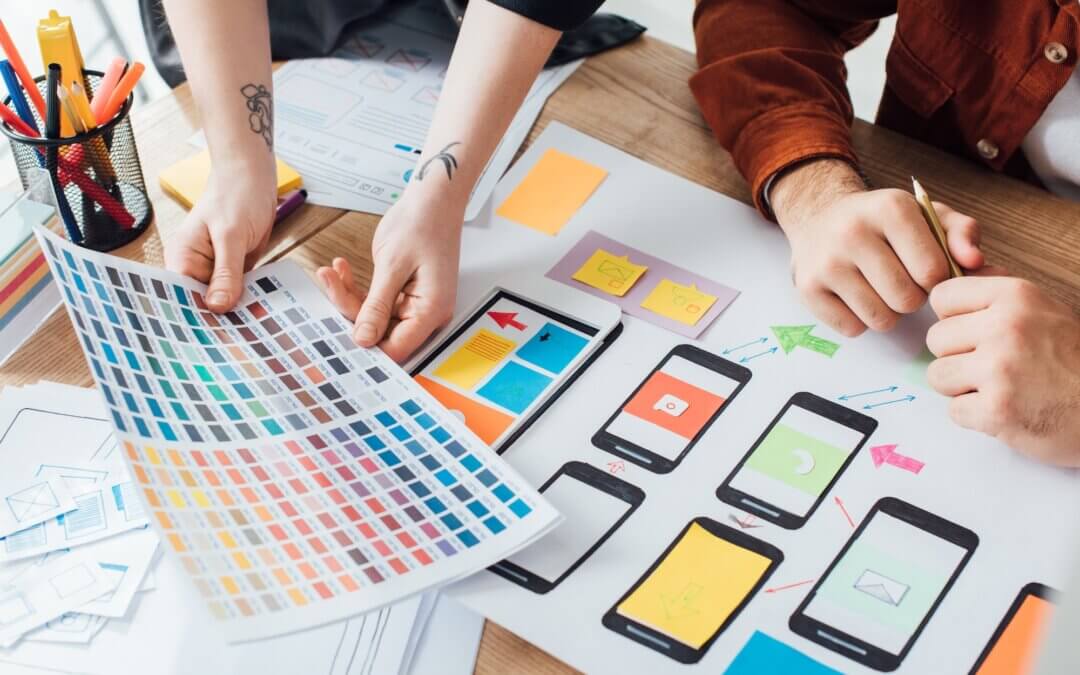 designers planning user experience design with color palette and website sketches